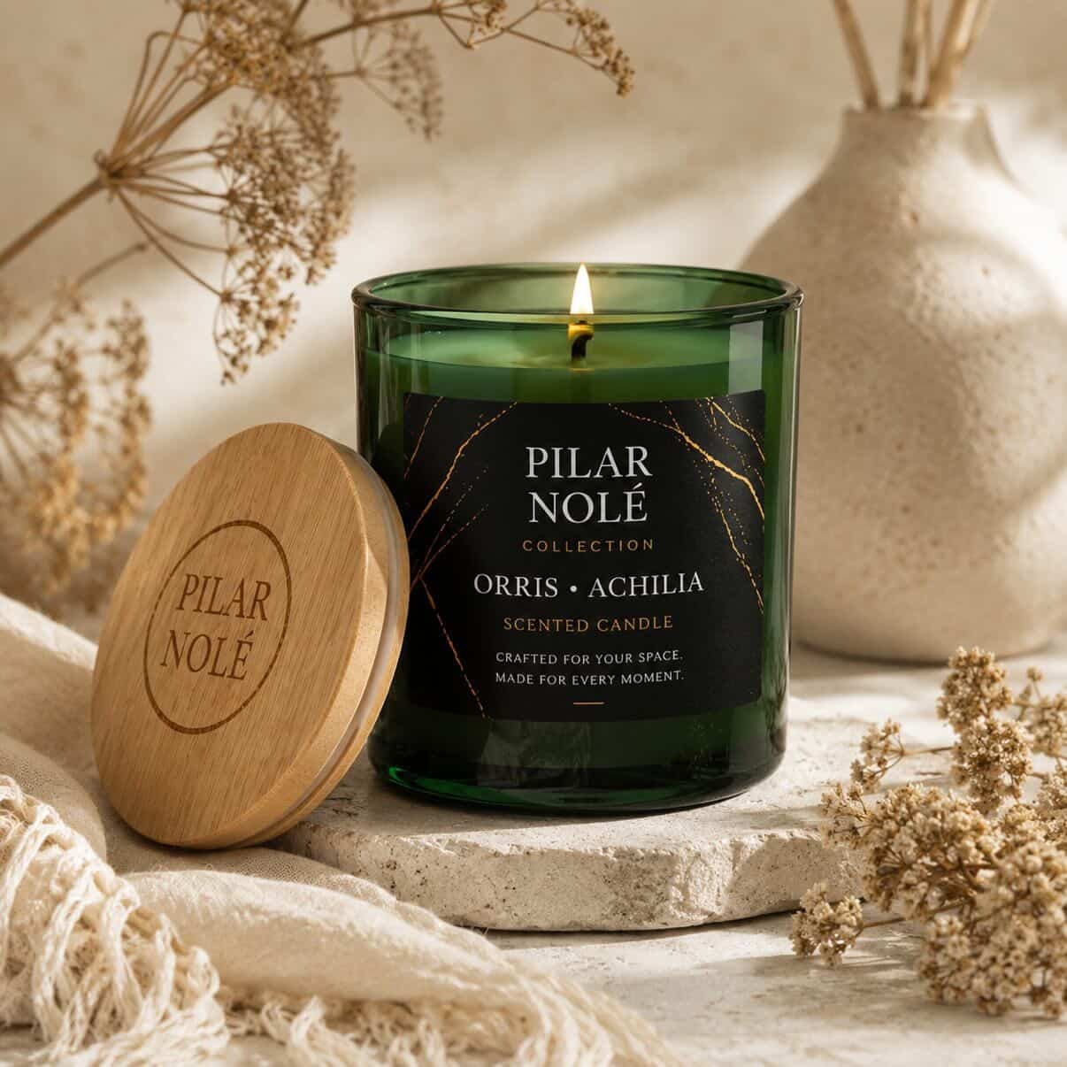Orris Achilia scented soy candle by Pilar Nolé in green glass vessel with engraved wooden lid